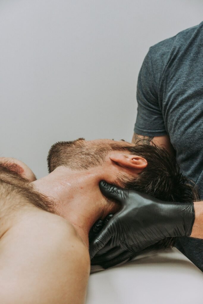 Fisioterapeuta realizando terapia manual en el cuello de un paciente