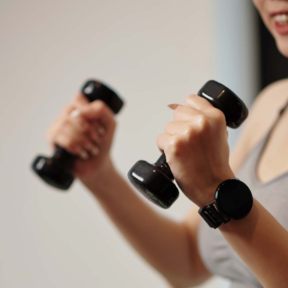 Manos sosteniendo pesas negras durante un entrenamiento
