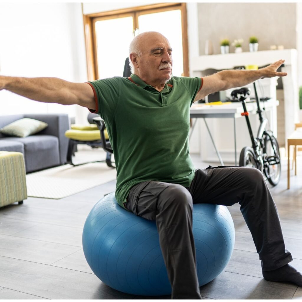 Hombre mayor realizando ejercicios de equilibrio sobre una pelota de fitness azul