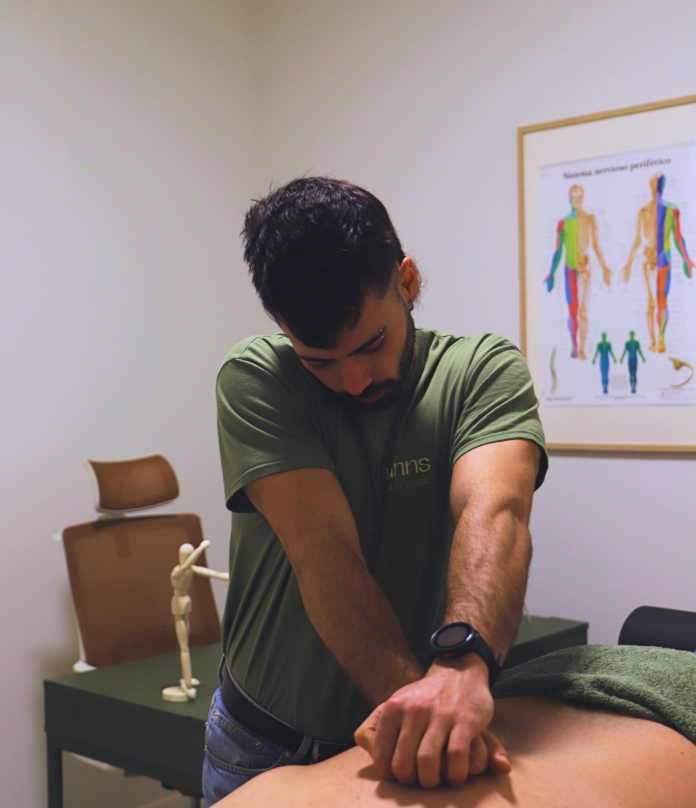 Hombre mayor realizando ejercicios de equilibrio sobre una pelota de fitness azul